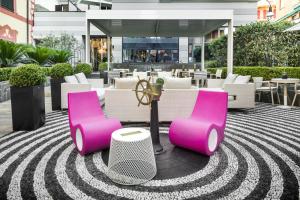 une terrasse avec des tables et des chaises roses et blanches dans l'établissement LHP Hotel Santa Margherita Palace & SPA, à Santa Margherita Ligure