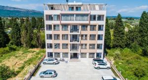 an apartment building with cars parked in a parking lot at Vista Apartments in Ulcinj