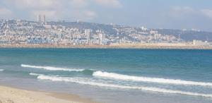 a view of the beach with a city in the background at Amazing in Haifa
