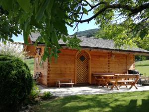 a wooden cabin with a picnic table and benches at Ferienwohnungen Bachbauer in Weyregg