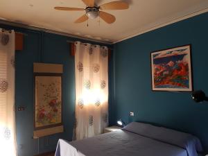 a blue bedroom with a bed and a ceiling fan at B&B William in Padova