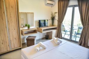 a bedroom with a bed and a tv and a balcony at Vista Apartments in Ulcinj