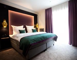 a bedroom with a large bed and a large window at ONNO Boutique Hotel & Apartments in Rendsburg