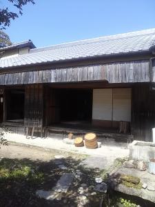 a barn with two hats sitting outside of it at Guesthouse Okagesan in Hongu