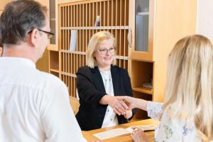 a woman shaking hands with a man at Appartment Hotel Victoria in Bad Füssing