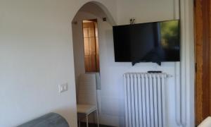 Casa delle Rose في Roa Marenca: تلفزيون بشاشة مسطحة معلق على جدار مع مشعاع +4 صور