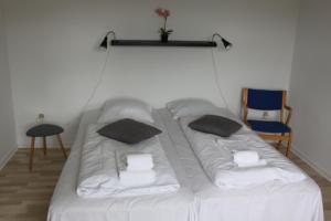 uma grande cama branca com duas almofadas em Motel Viborg em Viborg