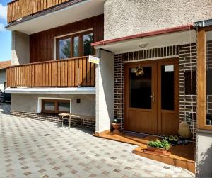 dom z drewnianymi drzwiami i patio w obiekcie Ubytovanie v súkromí w Liptowskim Janie