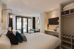 a hotel room with a large white bed with pillows at Les 2 Villas in Trouville-sur-Mer