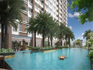 a large swimming pool with palm trees in front of a building at Sta.Mesa across SM Model Unit 2 BR in Manila