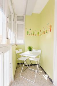 une table et des chaises blanches dans une pièce aux murs verts dans l'établissement Apartamento La Dama de Cadiz, à Cadix
