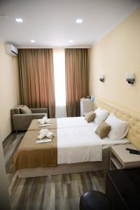 a hotel room with a large bed with towels on it at Hotel New Avlabari in Tbilisi City