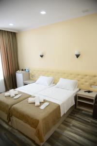 a bedroom with a large bed with towels on it at Hotel New Avlabari in Tbilisi City
