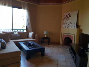 - un salon avec un canapé et une cheminée dans l'établissement Palmeraie village, à Marrakech