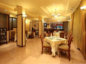 a dining room with a table and chairs in a room at Contessa Hotel in Shumen