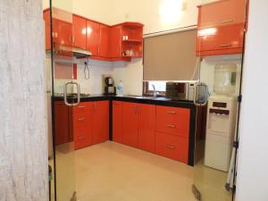 a kitchen with red cabinets and a refrigerator at Services (Self Catering) Villas 8 and 9 in Anjuna