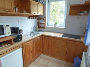 a kitchen with wooden cabinets and a sink and a window at FeWo Batek in Trechtingshausen