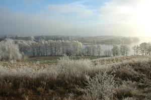 a foggy field with a lake in the background at U Przyjaciol Soni in Męcidół