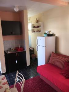 a living room with a red couch and a white refrigerator at Apartman Tatjana in Sutomore