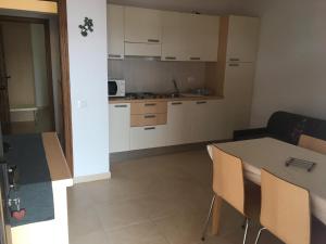 a kitchen with white cabinets and a table and chairs at Villa Carlotta Apartment Lajares in Lajares