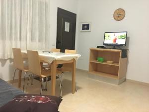 a dining room with a table and a television at Casa Carlotta Lajares in Lajares