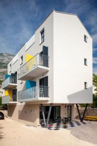 um edifício branco com varandas ao lado em SUBTUB Hostel Makarska em Makarska