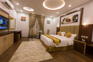 Luxury hotel apartments في تبوك: غرفة فندقية بسرير وتلفزيون بشاشة مسطحة