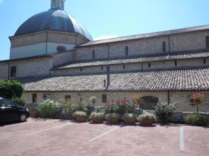 a building with potted plants in a parking lot at IL TURRIONE "app. Santa Chiara" in Assisi +2 photos