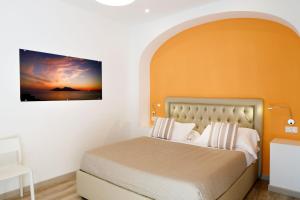 een slaapkamer met een bed met een oranje muur bij Sorrento Comfort Rooms con piscina in Sorrento