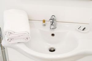 a white bathroom sink with a towel on it at Sorrento Comfort Rooms con piscina in Sorrento