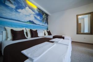 ein Hotelzimmer mit 2 Betten und einem Gemälde an der Wand in der Unterkunft Motel Aura in Mostar
