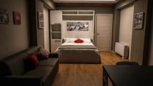 a bedroom with a bed and a couch and a television at Cascina Tumas Orta Lake in Pettenasco