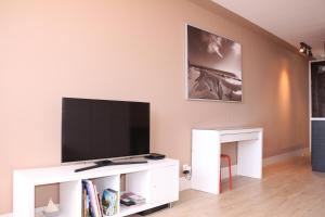 een woonkamer met een flatscreen-tv op een wit entertainmentcentrum bij Studio Palavas proche plage in Palavas-les-Flots