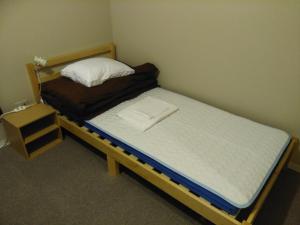 a bedroom with two bunk beds and a bed with a night stand at Mori ノ Guesthouse in Tenri