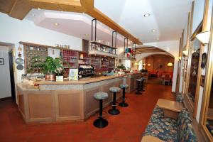 a restaurant with a bar with stools in a room at Hotel Capitani in Bormio