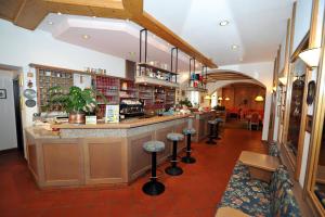 un ristorante con bar con sgabelli in camera di Hotel Capitani a Bormio