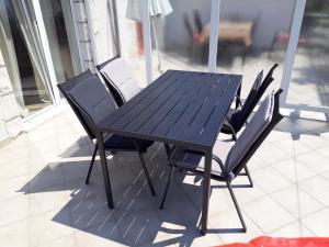 Apartment Ivana في فيغاني: طاولة وكراسي خشبية على الفناء