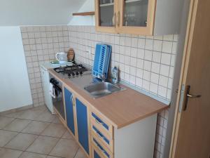 uma pequena cozinha com um lavatório e um fogão em Apartment Ivana em Viganj