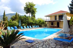 a villa with a swimming pool with chairs and an umbrella at Villa Nefeli in Yenion
