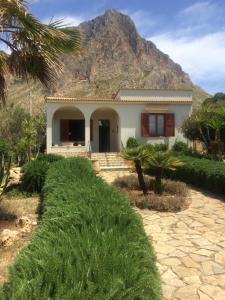 a house with a mountain in the background at Villa “La Giummarra” - Scivolo di Cornino in Custonaci