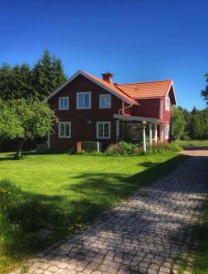 ein großes rotes Haus mit einer Ziegelsteinfahrt in der Unterkunft Det Gamla Panget in Tällberg