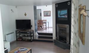 ein Wohnzimmer mit einem TV und einem Kamin in der Unterkunft Maison jardin grande piscine , sortie bateau possible in Marseille