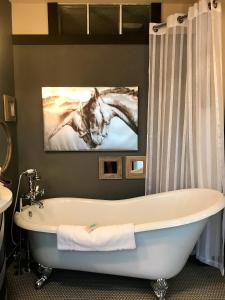 a bath tub in a bathroom with two horses on the wall at Colter's Lodge in Afton