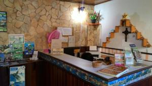 un comptoir dans un restaurant avec un mur en pierre dans l'établissement Pousada Montreux, à Praia do Forte