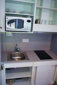 a kitchen with a sink and a microwave at A Cabana de Carmen in Cabana Moura 