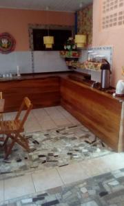 a kitchen with a counter and a chair in a room at Pousada Montreux in Praia do Forte +6 photos