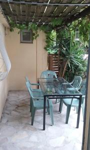 a glass table and chairs on a patio at Maison jardin grande piscine , sortie bateau possible in Marseille