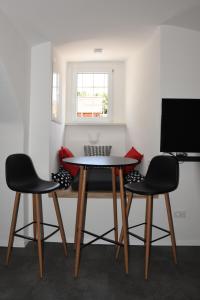 a table and three chairs in a room at Fortezza Ljubljana Center in Ljubljana