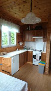 eine Küche mit Holzschränken und einem weißen Herd mit Backofen in der Unterkunft Domek nad jeziorem in Suwałki