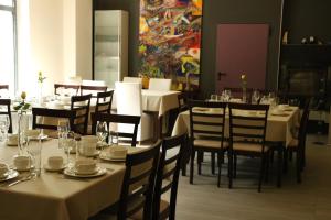 a dining room with tables and chairs and a painting at Villa Art Korab in Gliwice